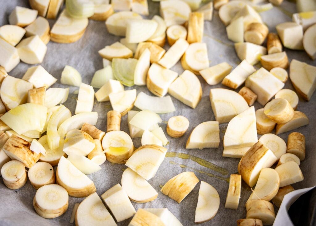 knolselderij en pastinaak roosteren in de oven om soep van te maken